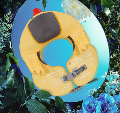 Yellow inflatable neck collar with red button on a blue background surrounded by green leaves and flowers