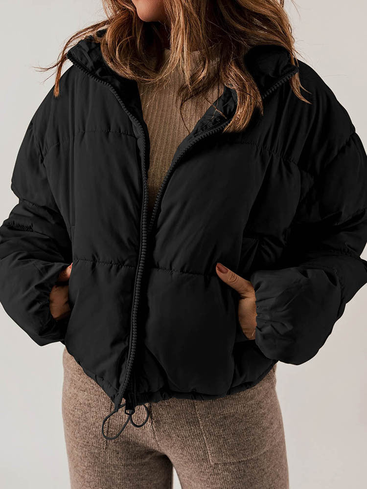 Person wearing a black puffer jacket with a neutral background