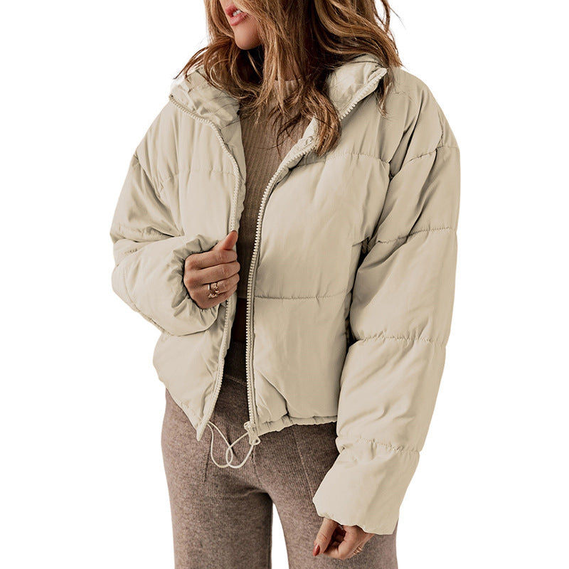 Person wearing a beige puffer jacket on a white background