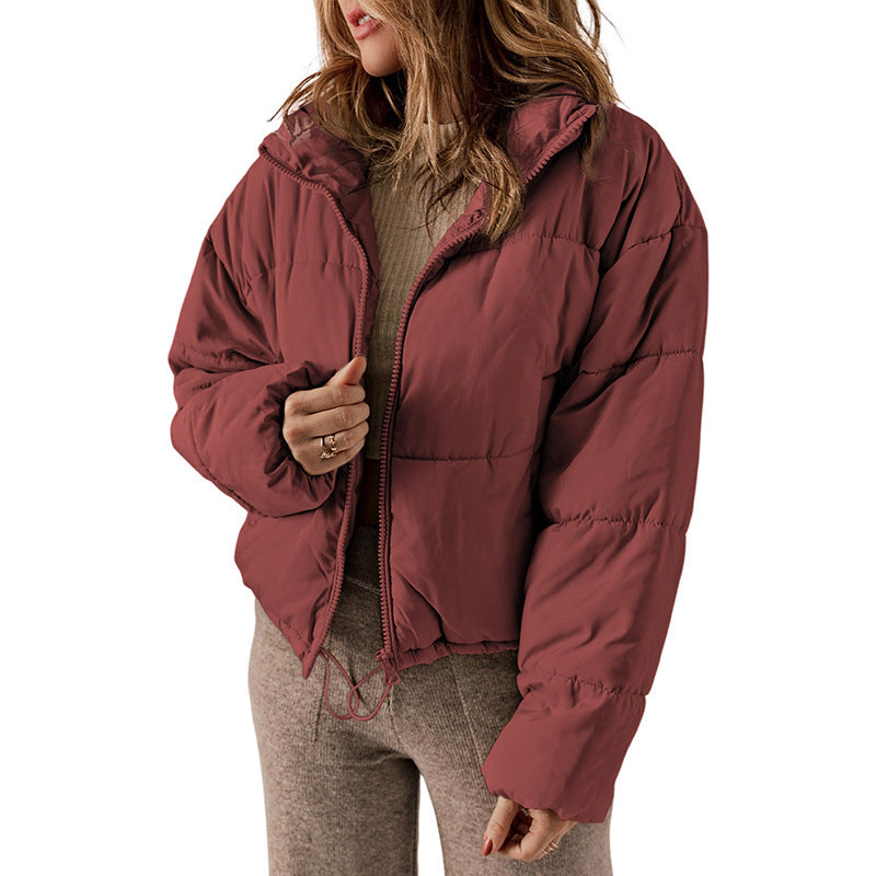 Person wearing a maroon puffer jacket on a white background