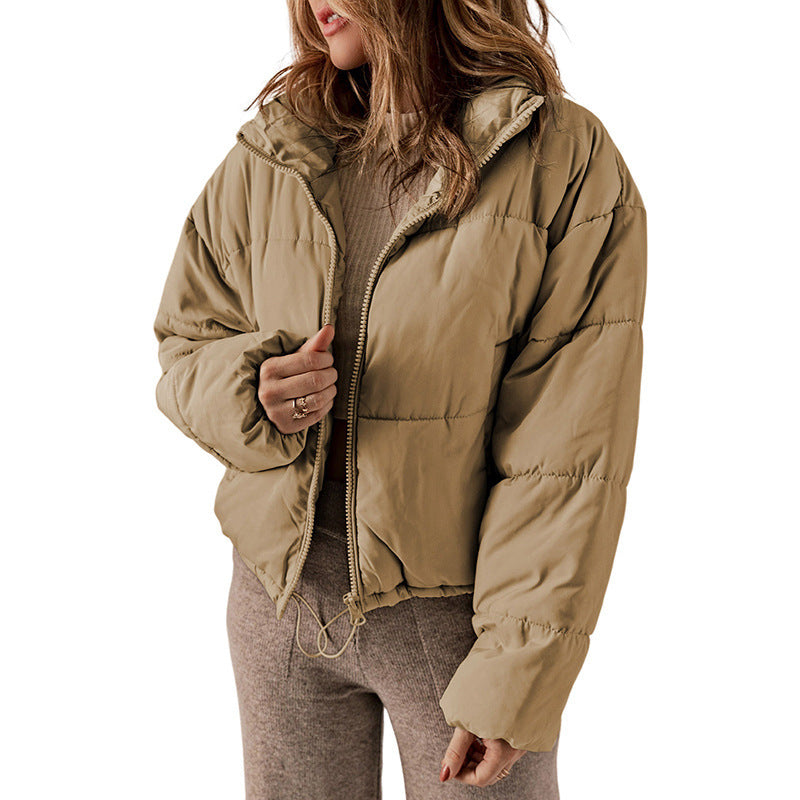 Person wearing a beige puffer jacket on a white background