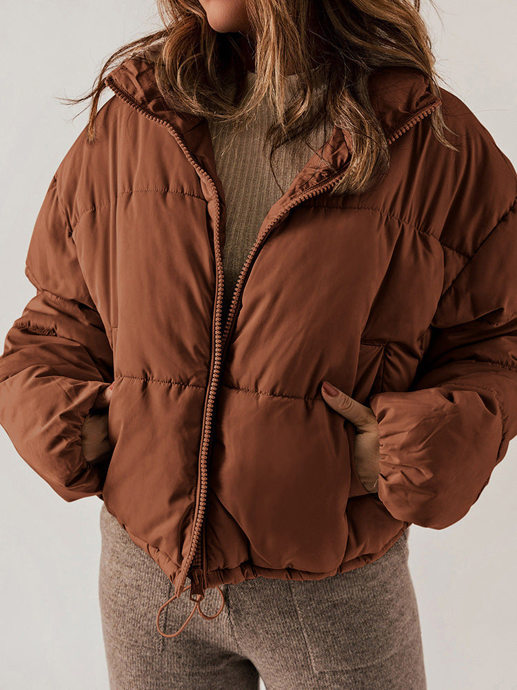 Brown puffer jacket worn by a person on a plain background