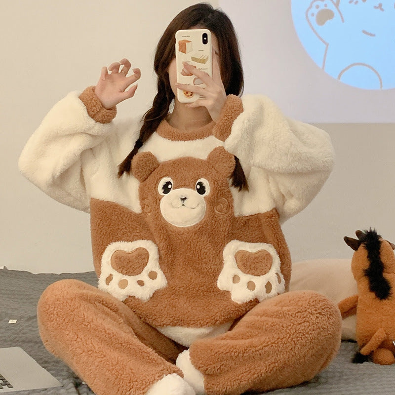 Person wearing a brown and white bear-themed pajama set sitting on a bed.
