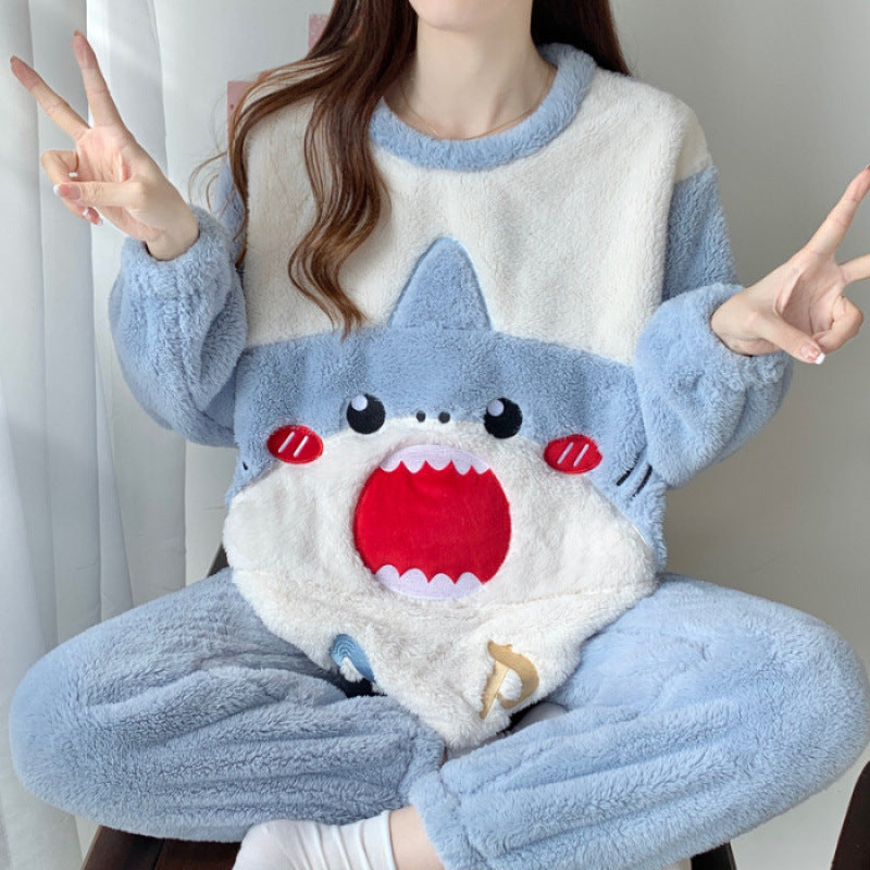 Person wearing a blue and white shark-themed pajama set with a pillow on their lap.