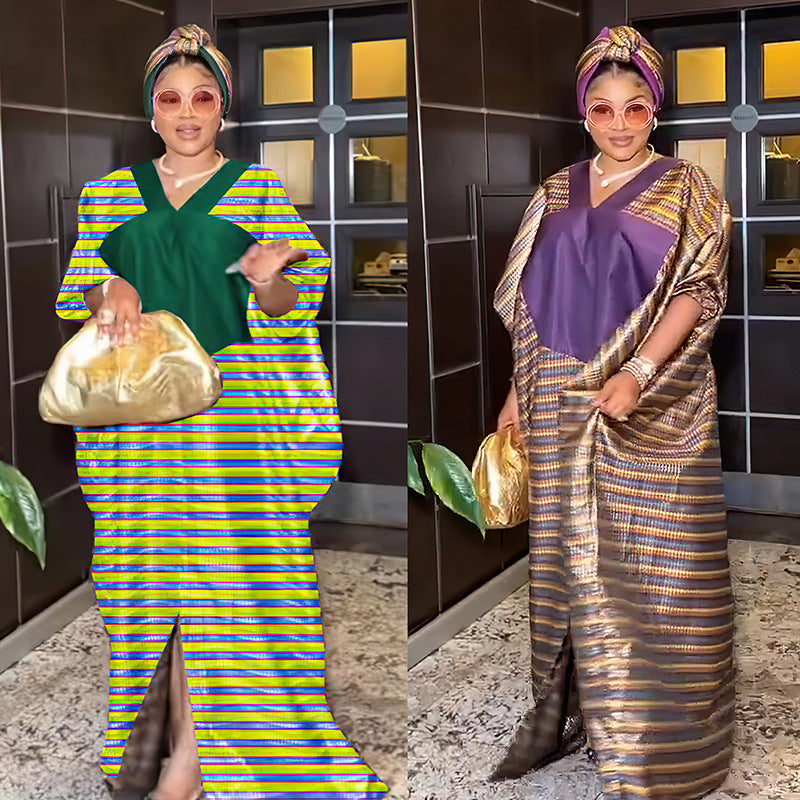 Two women in traditional attire with colorful dresses and headwraps, holding gold bags.