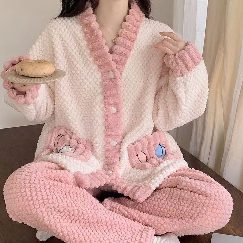 Person wearing a pink and white fluffy outfit holding a donut.