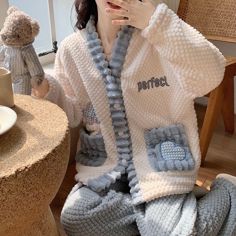 Person wearing a fluffy robe with text and heart designs, sitting on a chair.