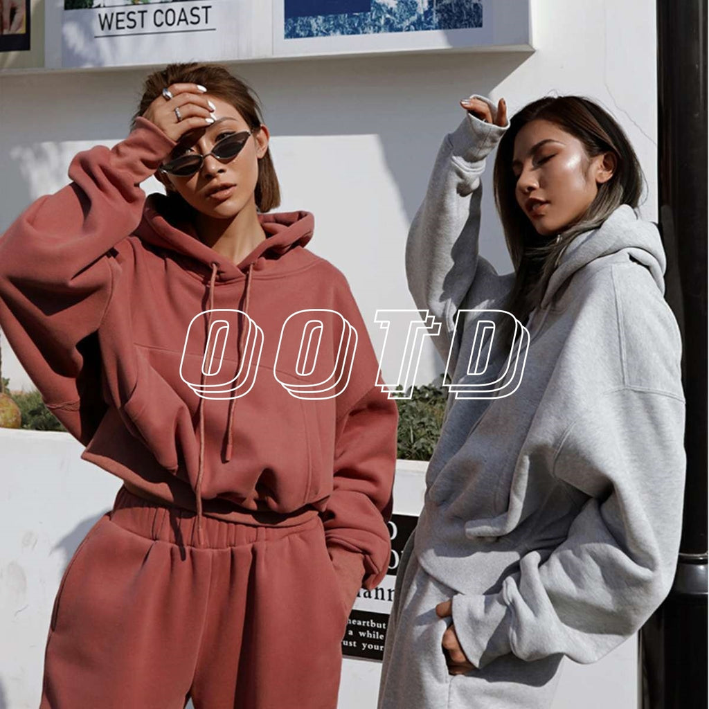 Two people wearing hoodies with 'OOTD' text in an urban setting.