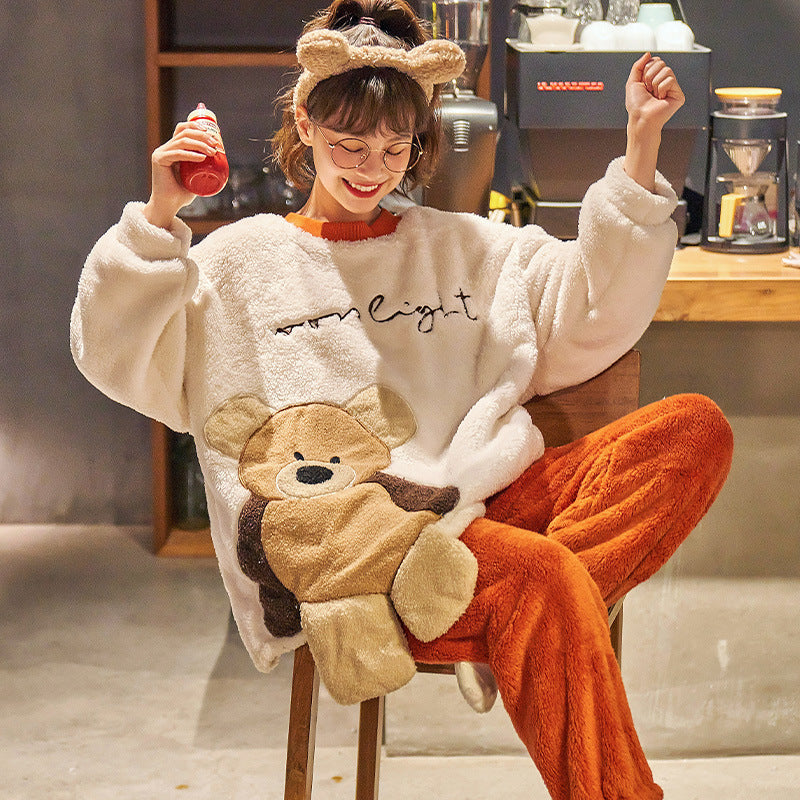 Person wearing a cozy outfit with a bear design, sitting in a room.