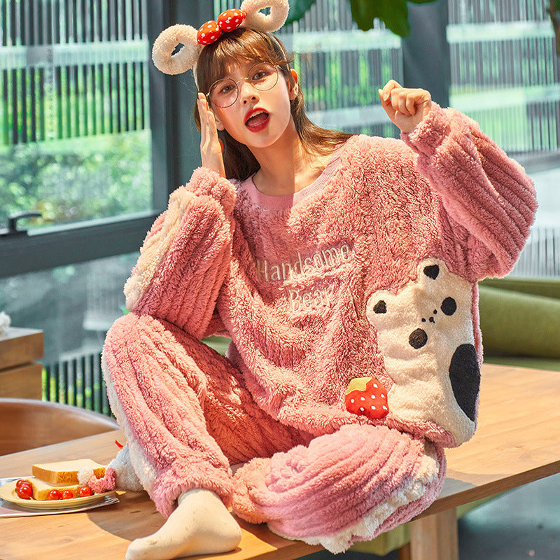 Woman wearing a pink plush pajama set with bear design indoors.