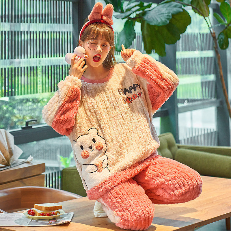 Person wearing a cozy pink and beige outfit with a teddy bear design, sitting at a table.
