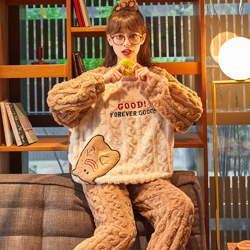 Person wearing a cozy outfit with a sweater and pajama set, sitting on a couch.